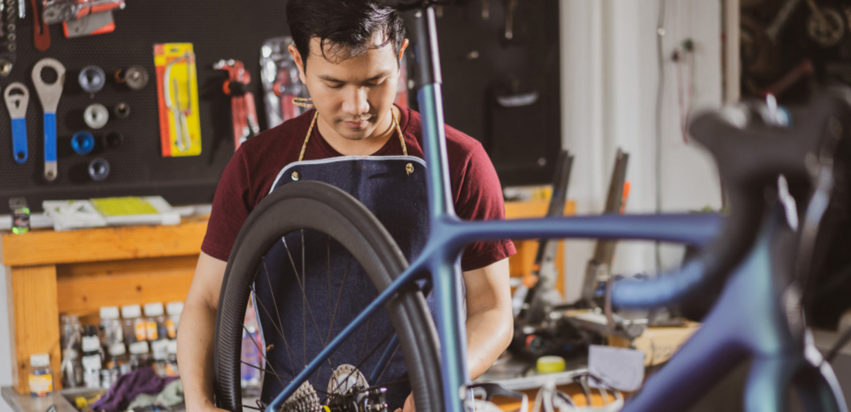 Junger Migrant repariert ein Fahrrad