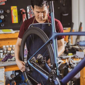 Junger Migrant repariert ein Fahrrad